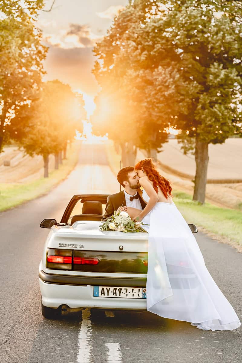 After-Wedding-Shooting in Lothringen, Frankreich. Brautpaar in einer Allee mit Blick Richtung Sonnenuntergang im Sommer.